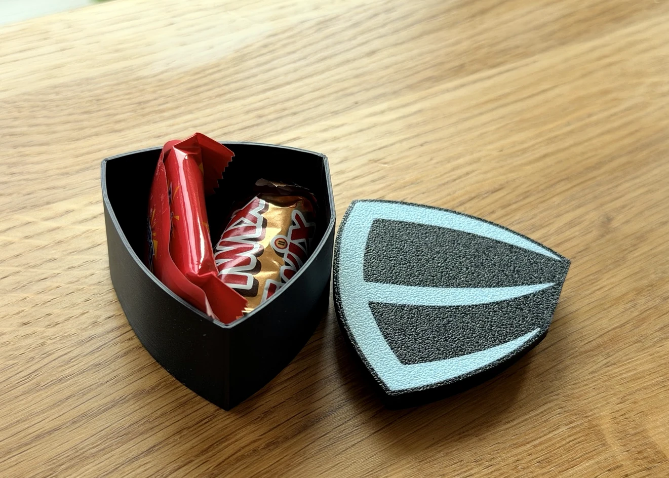Öppen EnlightSec-box med en Daim inuti och det logotypformade locket bredvid.