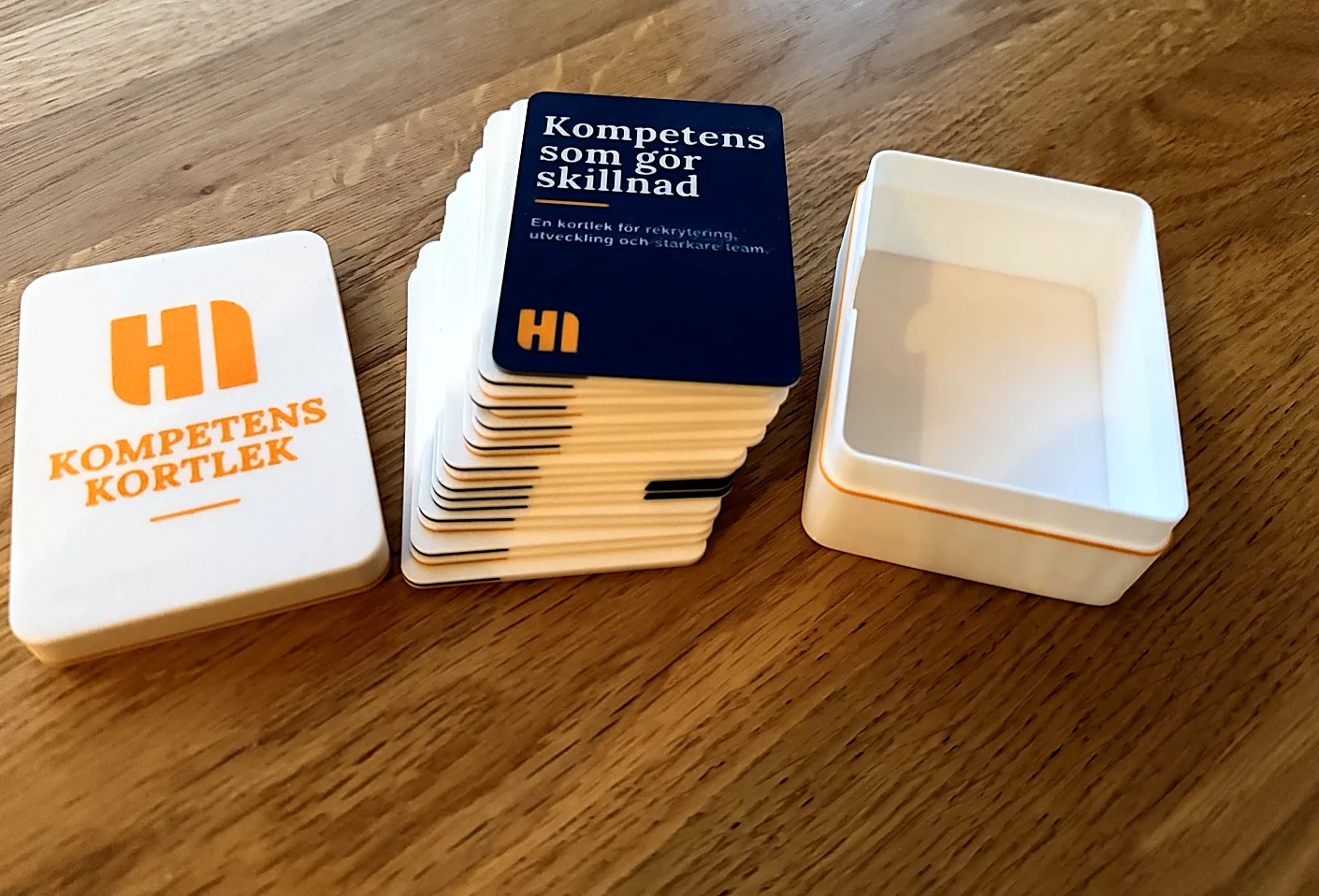 Kortleken med omslagskortet överst, mellan asklocket och den öppna asken.
